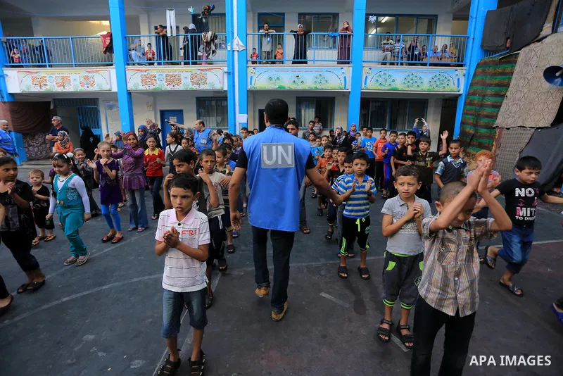 Palestinian children enjoy in games in the courtyard of a UN school, that shelters hundreds of families after fighting between Israel and Hamas broke out July 8, during a morning activity on the day that schools across G...