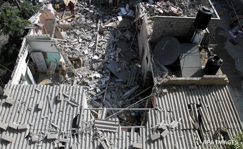 Palestinian men inspect the rubble of their house following an Israeli air strike in Deir al-Balah in the central Gaza strip on August 24, 2014. Egypt called on Israel and the Palestinians on Saturday to halt hostilities...