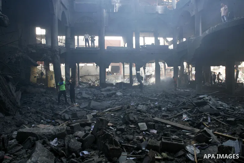 Palestinians look at the remains of a commercial center, which witnesses said was hit by an Israeli air strike on Saturday, in Rafah in the southern Gaza Strip August 24, 2014. Egypt called on Israel and the Palestinians...