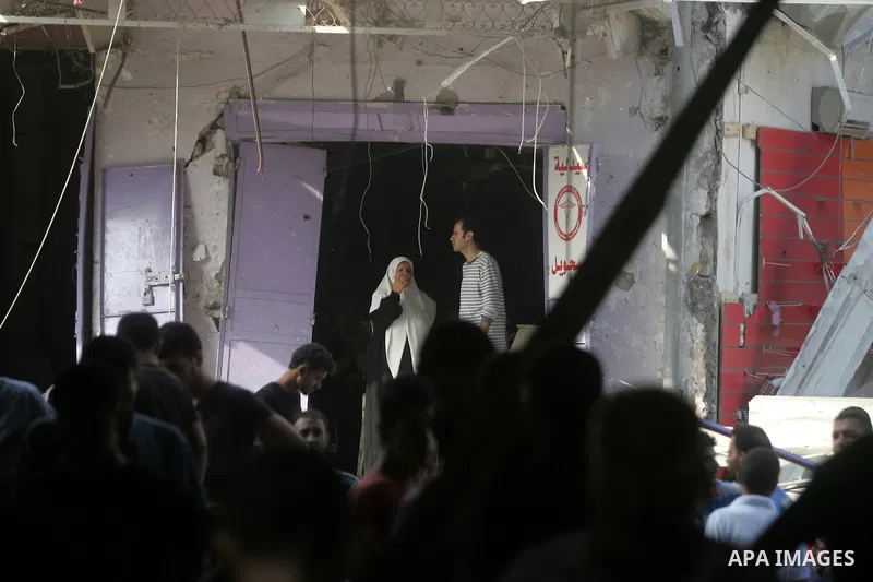 Palestinians look at the remains of a commercial center, which witnesses said was hit by an Israeli air strike on Saturday, in Rafah in the southern Gaza Strip August 24, 2014. Egypt called on Israel and the Palestinians...