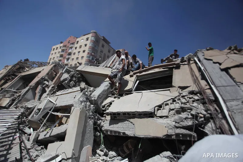 Palestinians collect their belongings from under the rubble of a residential tower, which witnesses said was destroyed in an Israeli air strike in Gaza City August 24, 2014. Egypt called on Israel and the Palestinians on...
