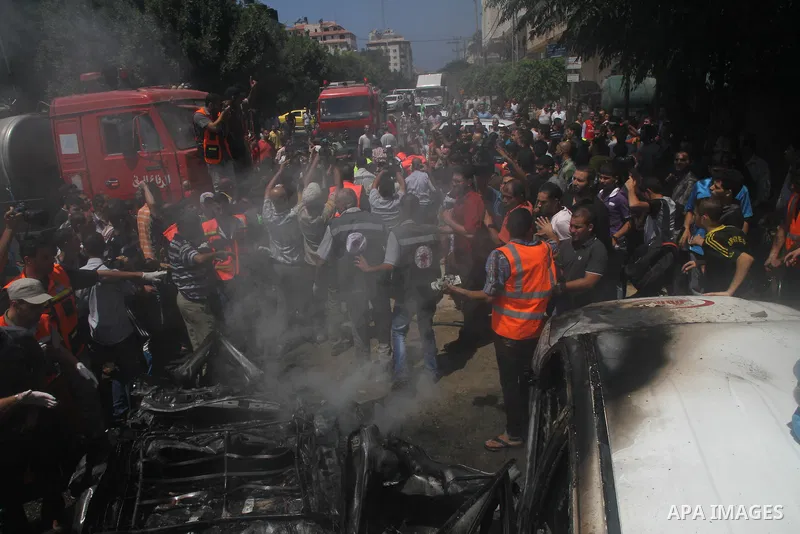 Palestinians gather around the remains of a car, which witnesses said was hit by an Israeli air strike, in Gaza City August 24, 2014. Israel launched more air strikes on Gaza on Sunday after taking its military campaign...
