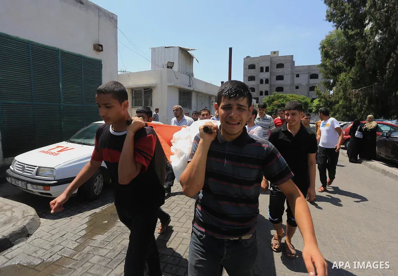 Palestinian mourners carry the body of Mohammed Al KHodary, 17, who medics said was killed by an Israeli air strike, during his funeral in the Gaza city August 24, 2014. Israel launched more air strikes on Gaza on Sunday...