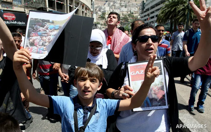 Palestinians hold pictures of children who were killed in the Israeli attack on the Gaza Strip during a march against the war in the Gaza Strip in the West Bank city of Nablus on August 24, 2014. Israel launched more air...