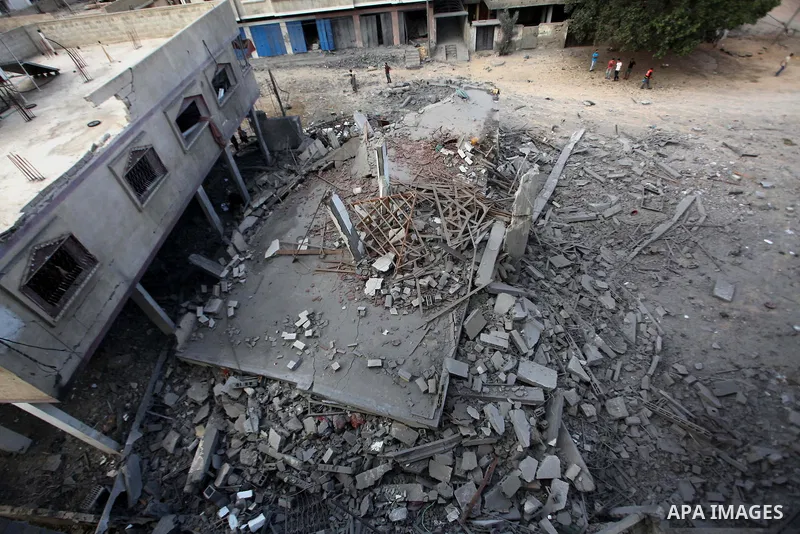 A Palestinian man inspects a building of al-Ghul's house after it was targeted in an Israeli airstrike in Gaza City on August 25, 2014. One of Sunday's air strikes killed Hamas financial official Mohammed al-Ghul as he w...