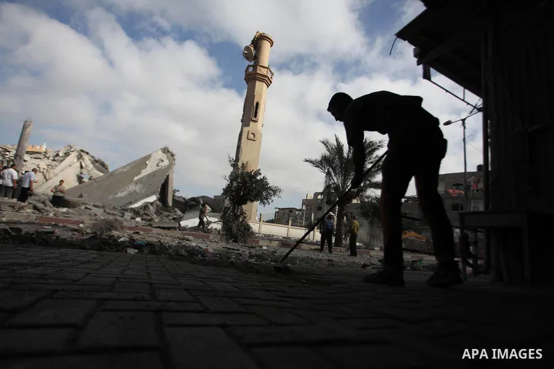 A Palestinian man sweeps the floor of his home that was damaged after a mosque across the street was hit by an Israeli airstrike on August 25, 2014, August 25, 2014. Israel's Prime Minister Benjamin Netanyahu warned Pale...