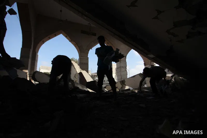 A Palestinian man collects pages of the Koran from the remains of a mosque, which witnesses said was hit by an Israeli air strike, in Beit Hanoun in the northern Gaza Strip August 25, 2014. Israel's Prime Minister Benjam...