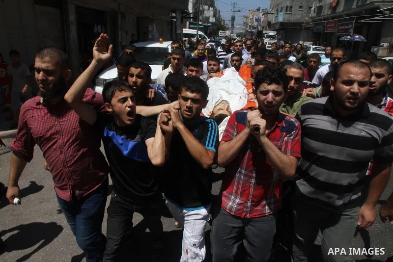 Mourners carry the body of of Palestinian Osama Shabbir, whom medics said was killed in an Israeli air strike, during his funeral in Jabaliya in the northern Gaza Strip August 25, 2014. Israel's Prime Minister Benjamin N...