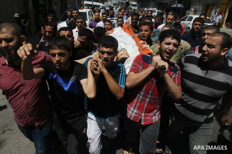 Mourners carry the body of of Palestinian Osama Shabbir, whom medics said was killed in an Israeli air strike, during his funeral in Jabaliya in the northern Gaza Strip August 25, 2014. Israel's Prime Minister Benjamin N...