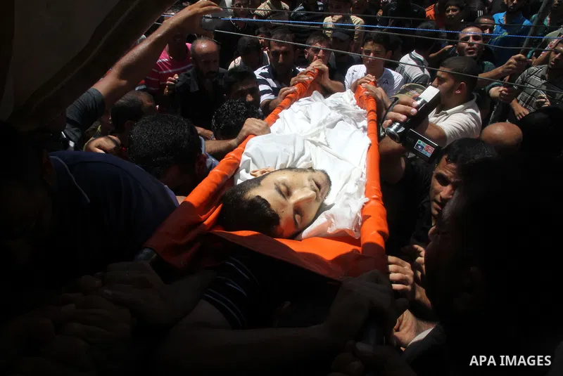 Mourners carry the body of of Palestinian Osama Shabbir, whom medics said was killed in an Israeli air strike, during his funeral in Jabaliya in the northern Gaza Strip August 25, 2014. Israel's Prime Minister Benjamin N...
