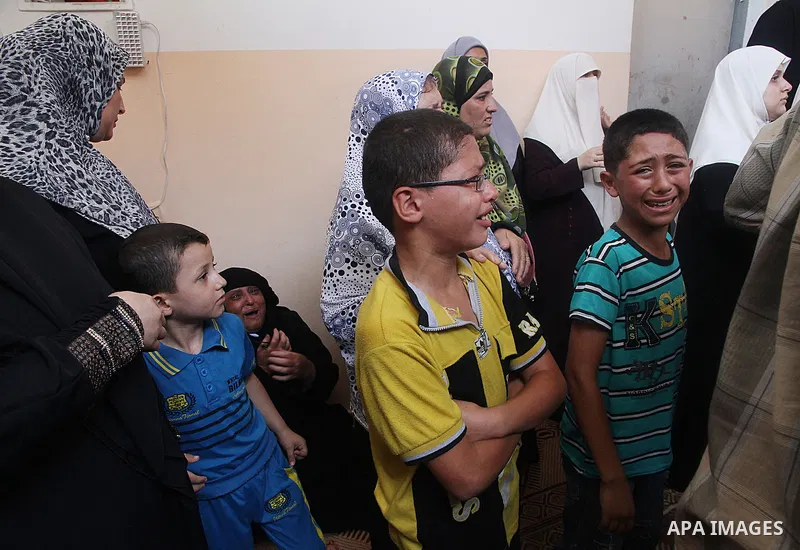 Palestinian relatives mourn on the body of of Palestinian Osama Shabbir, whom medics said was killed in an Israeli air strike, during his funeral in Jabaliya in the northern Gaza Strip August 25, 2014. Israel's Prime Min...