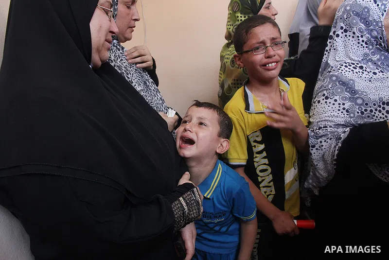 Palestinian relatives mourn on the body of of Palestinian Osama Shabbir, whom medics said was killed in an Israeli air strike, during his funeral in Jabaliya in the northern Gaza Strip August 25, 2014. Israel's Prime Min...