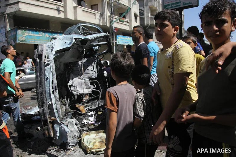 Palestinians surround a wreckage of a car which witnesses said was hit by an Israeli air strike, in Gaza City August 25, 2014. Israeli air strikes killed at least five Palestinians in the Gaza Strip and militants kept up...