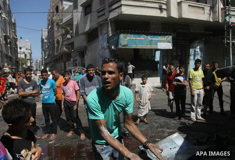 Palestinians surround a wreckage of a car which witnesses said was hit by an Israeli air strike, in Gaza City August 25, 2014. Israeli air strikes killed at least five Palestinians in the Gaza Strip and militants kept up...