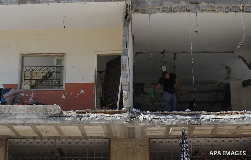 A Palestinian man inspects a house targeted in an Israeli air strike in Gaza city on August 25, 2014. Israel's Prime Minister Benjamin Netanyahu warned Palestinian civilians on Sunday to leave immediately any site where...