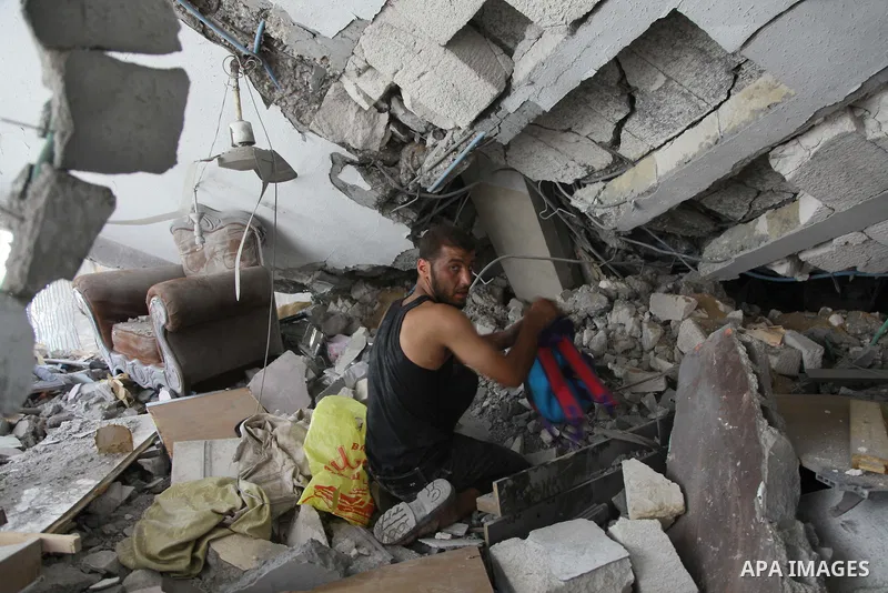 A Palestinian man inspects a house targeted in an Israeli air strike in Gaza city on August 25, 2014. Israel's Prime Minister Benjamin Netanyahu warned Palestinian civilians on Sunday to leave immediately any site where...