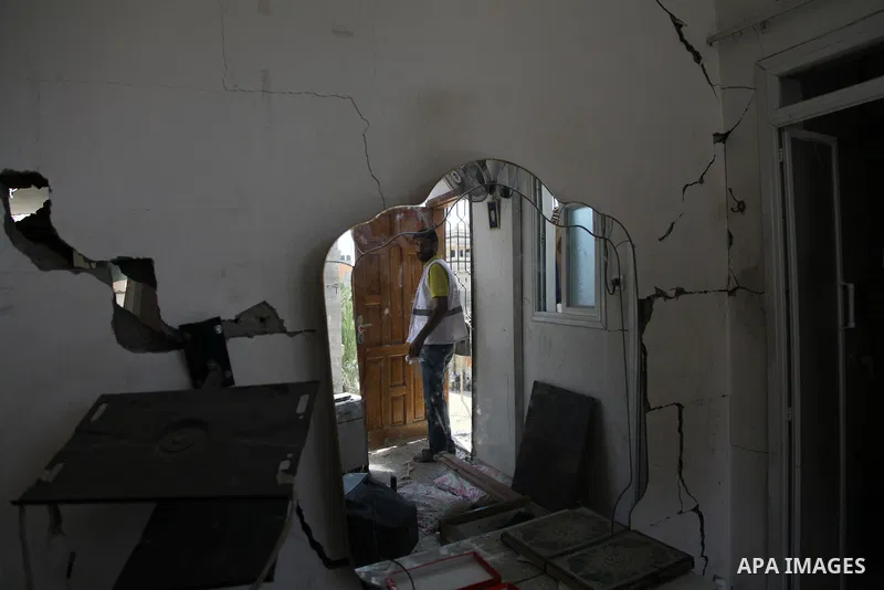 A Palestinian man inspects a house targeted in an Israeli air strike in Gaza city on August 25, 2014. Israel's Prime Minister Benjamin Netanyahu warned Palestinian civilians on Sunday to leave immediately any site where...