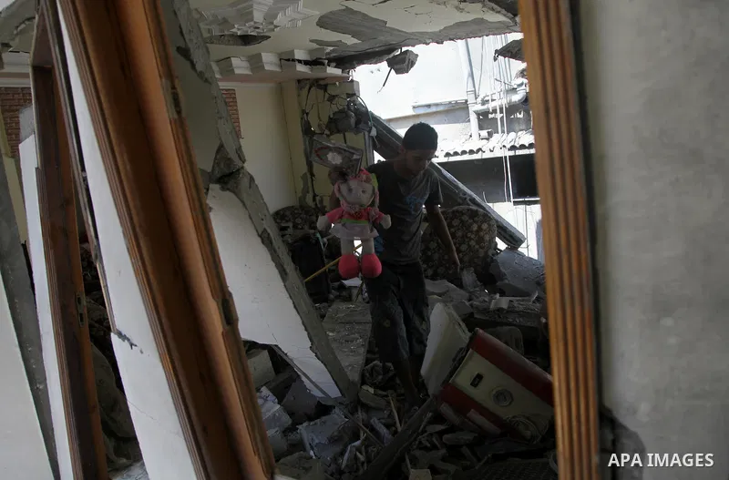 A Palestinian man inspects a house targeted in an Israeli air strike in Gaza city on August 25, 2014. Israel's Prime Minister Benjamin Netanyahu warned Palestinian civilians on Sunday to leave immediately any site where...