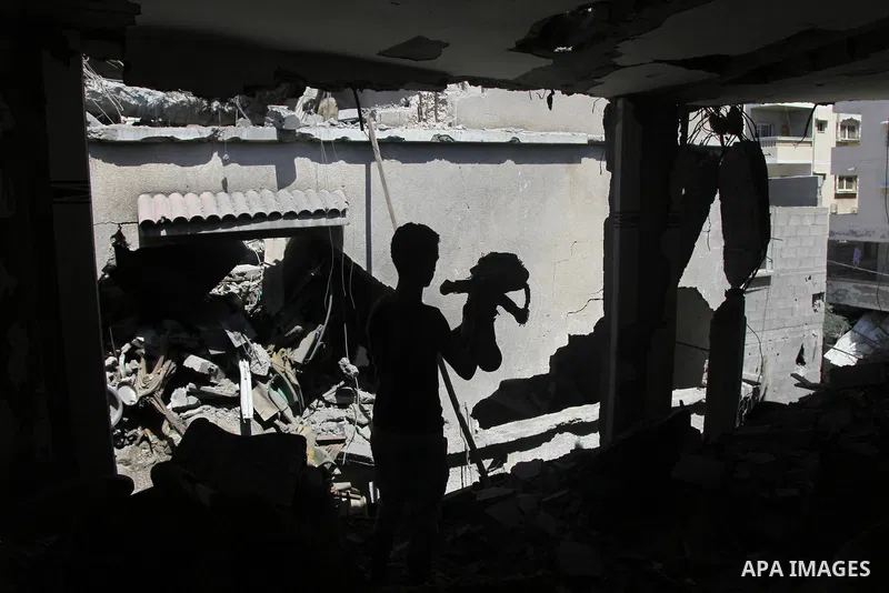 A Palestinian man inspects a house targeted in an Israeli air strike in Gaza city on August 25, 2014. Israel's Prime Minister Benjamin Netanyahu warned Palestinian civilians on Sunday to leave immediately any site where...