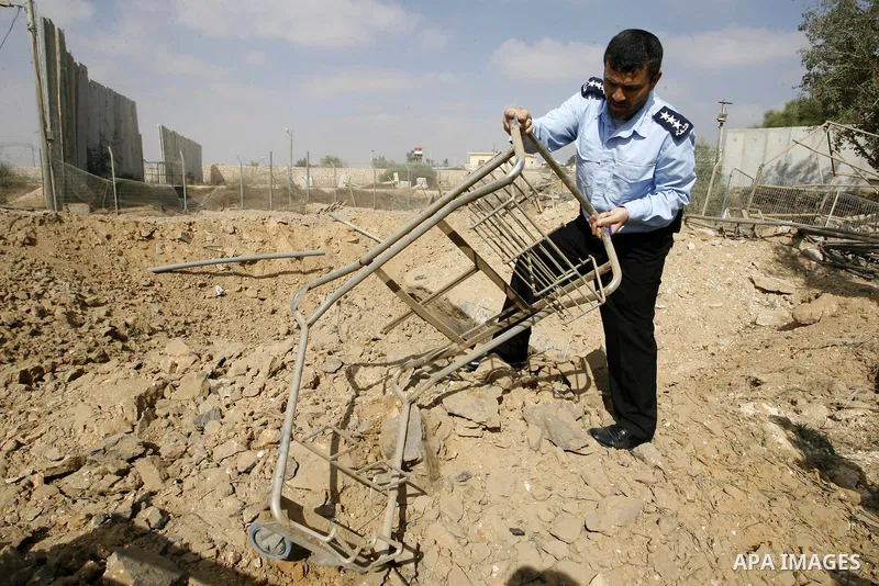 A member of the Palestinian security forces inspects the damage from an Israeli air strike at the Rafah border crossing with Egypt in the southern Gaza Strip on August 25, 2014. Violence reverberated across Gaza with fou...
