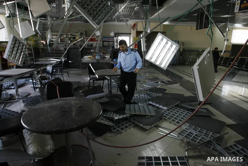 A Palestinian inspects the damage from an Israeli air strike to the departure lounge of the Rafah border crossing with Egypt in the southern Gaza Strip on August 25, 2014. Violence reverberated across Gaza with four Pale...