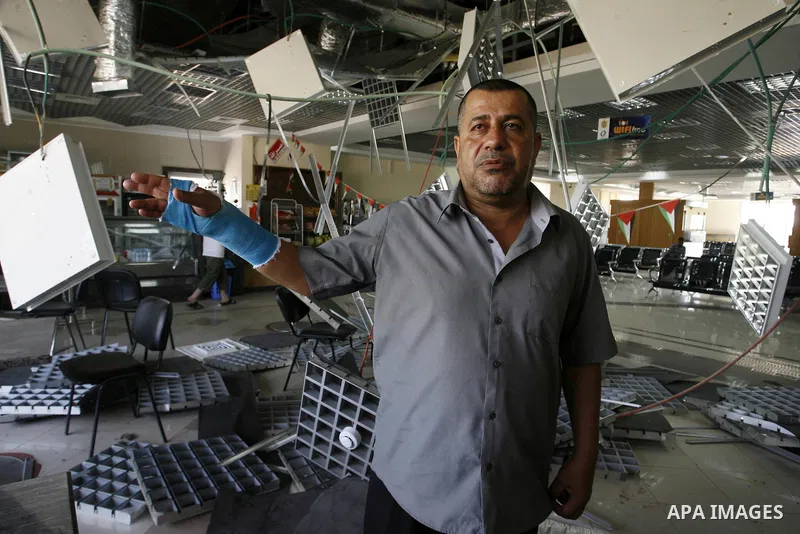 A Palestinian inspects the damage from an Israeli air strike to the departure lounge of the Rafah border crossing with Egypt in the southern Gaza Strip on August 25, 2014. Violence reverberated across Gaza with four Pale...