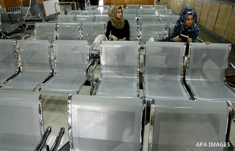 Palestinian travellers wait before crossing into Egypt near damage, from an Israeli air strike, in the departure lounge of the Rafah border crossing with Egypt in the southern Gaza Strip on August 25, 2014. Violence reve...