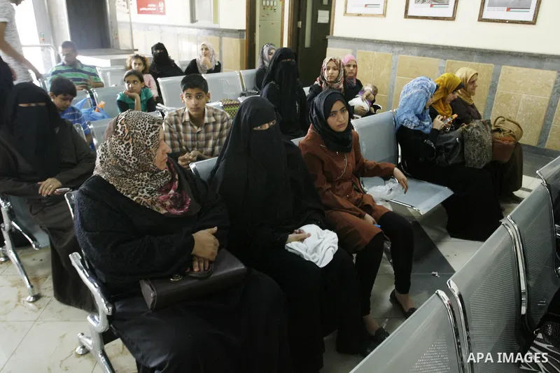 Palestinian travellers wait before crossing into Egypt near damage, from an Israeli air strike, in the departure lounge of the Rafah border crossing with Egypt in the southern Gaza Strip on August 25, 2014. Violence reve...