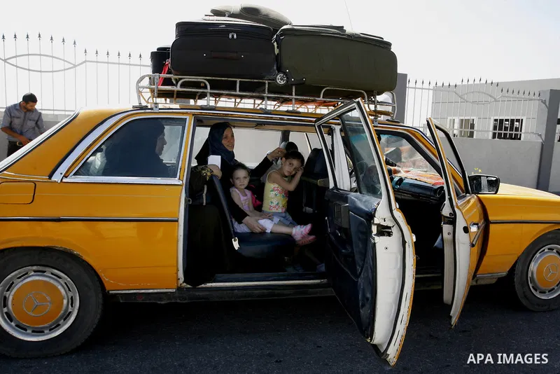 Palestinian travellers wait before crossing into Egypt at the Rafah border crossing with Egypt in the southern Gaza Strip on August 25, 2014. Violence reverberated across Gaza with four Palestinians killed in Israeli air...