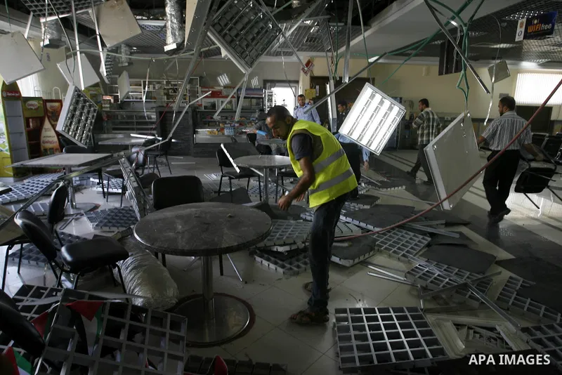 A Palestinian inspects the damage from an Israeli air strike to the departure lounge of the Rafah border crossing with Egypt in the southern Gaza Strip on August 25, 2014. Violence reverberated across Gaza with four Pale...