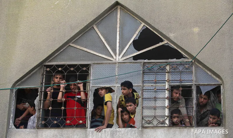 Palestinians mourn over the bodies of Basim Hijazi 36, his brother Ahmed, 26, and a friend Mohamad al-Dali who were killed when their car was hit by an Israeli air strike during their funeral in Gaza City on August 25, 2...