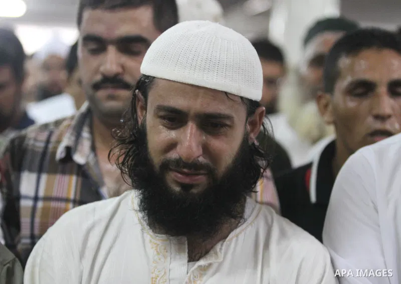 Palestinians mourn over the bodies of Basim Hijazi 36, his brother Ahmed, 26, and a friend Mohamad al-Dali who were killed when their car was hit by an Israeli air strike during their funeral in Gaza City on August 25, 2...