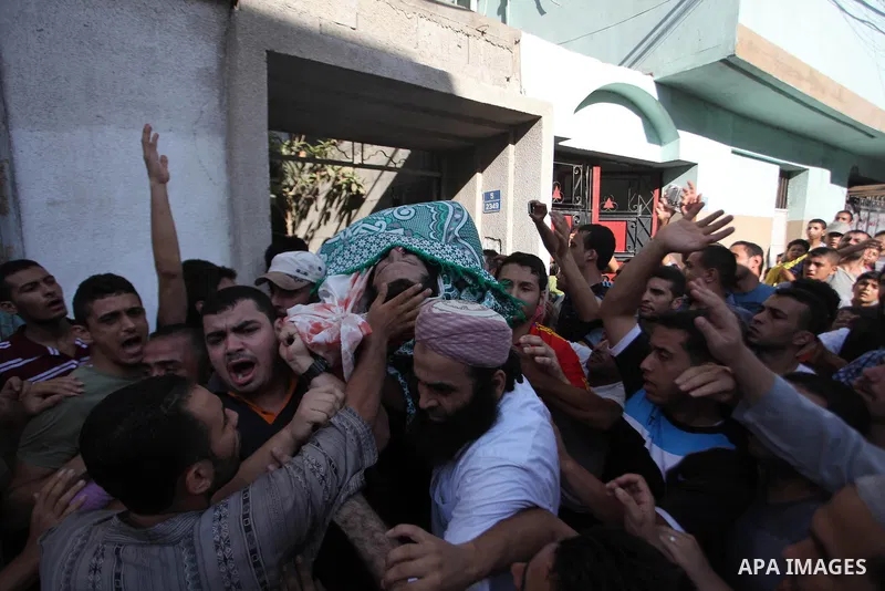Palestinian mourners carry the body of Basim Hijazi 36, after his car was targeted in an Israeli air strike also killing his brother Ahmed, 26, and a friend during their funeral in Gaza City on August 25, 2014. Palestini...