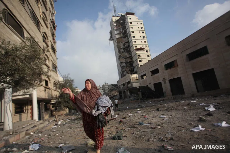 A Palestinian woman reacts next to the remains of one of Gaza's tallest apartment towers, which witnesses said was hit by an Israeli air strike that destroyed much of it, in Gaza City August 26, 2014. Israeli air strikes...