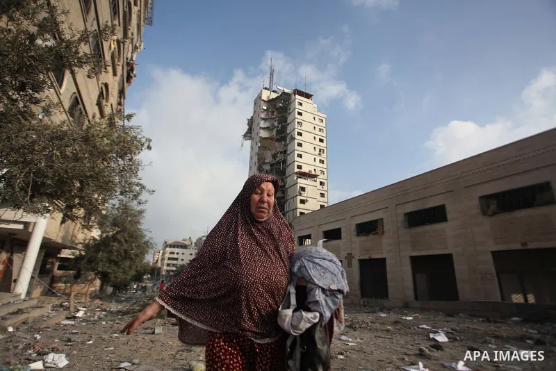 A Palestinian woman reacts next to the remains of one of Gaza's tallest apartment towers, which witnesses said was hit by an Israeli air strike that destroyed much of it, in Gaza City August 26, 2014. Israeli air strikes...
