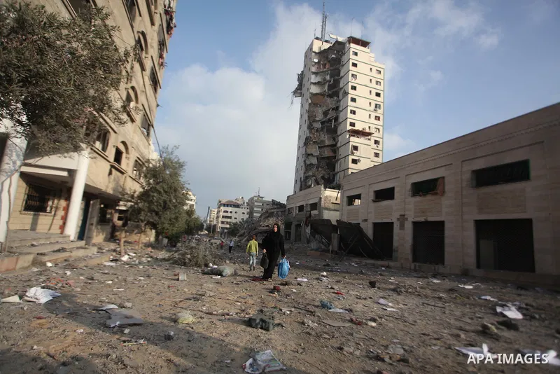 A Palestinian woman reacts next to the remains of one of Gaza's tallest apartment towers, which witnesses said was hit by an Israeli air strike that destroyed much of it, in Gaza City August 26, 2014. Israeli air strikes...