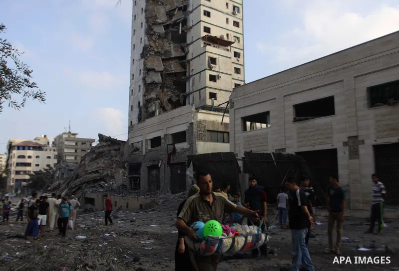 Palestinians collect their belongings from under the rubble of one of Gaza's tallest apartment towers, which witnesses said was hit by an Israeli air strike that destroyed much of it, in Gaza City August 26, 2014. Israel...