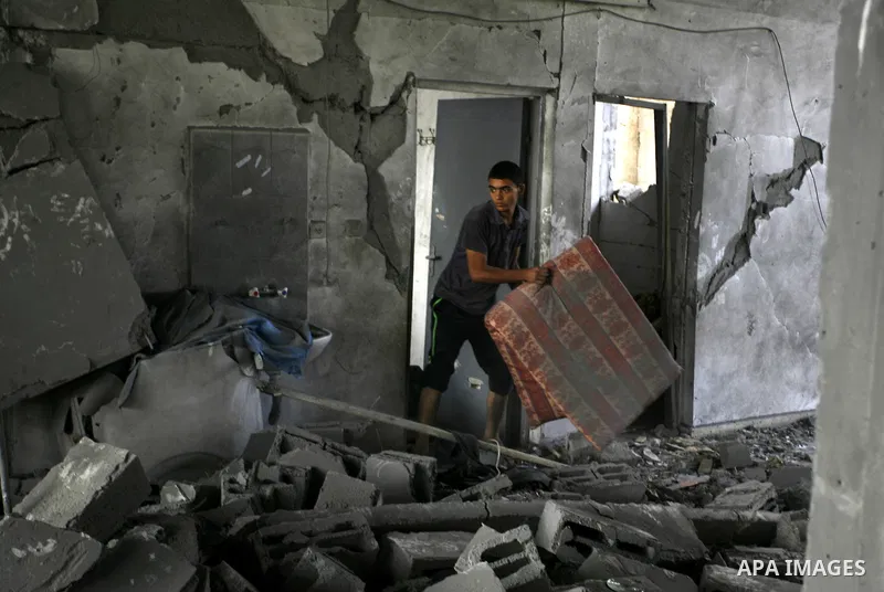 A Palestinian boy inspects the remains of his homes that was destroyed by an Israeli air strike on August 26, 2014. Israeli fire killed 10 Palestinians across Gaza on August 25, while Egypt proposed a new ceasefire that...