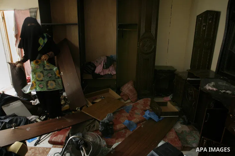 A Palestinian woman salvage items from the remains of her homes that was destroyed by an Israeli air strike on August 26, 2014. Israeli fire killed 10 Palestinians across Gaza on August 25, while Egypt proposed a new cea...