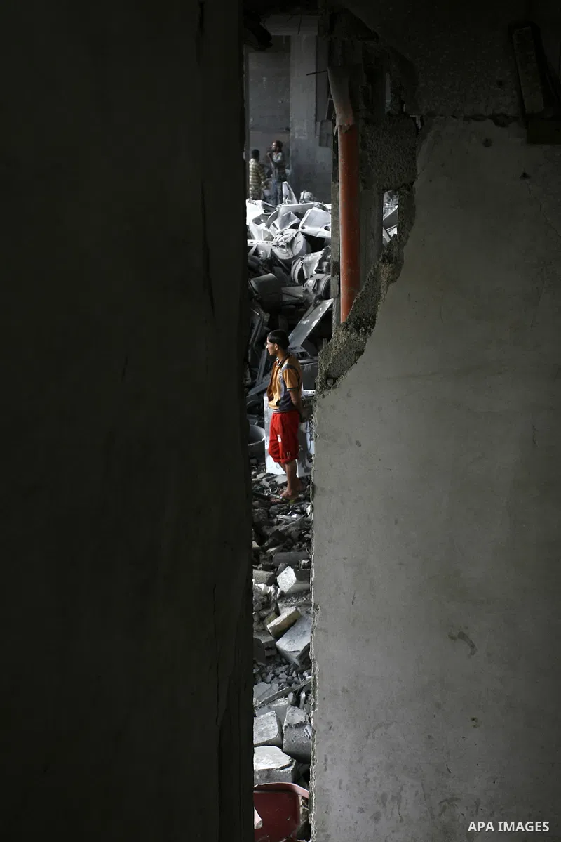 A Palestinian boy inspects the remains of his homes that was destroyed by an Israeli air strike on August 26, 2014. Israeli fire killed 10 Palestinians across Gaza on August 25, while Egypt proposed a new ceasefire that...