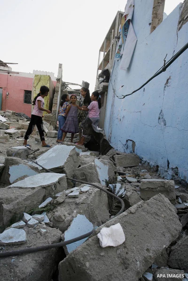 Palestinian children play near the remains of homes that were destroyed by an Israeli air strike on Rafah town in the southern Gaza Strip on August 26, 2014. Israeli fire killed 10 Palestinians across Gaza on August 25,...