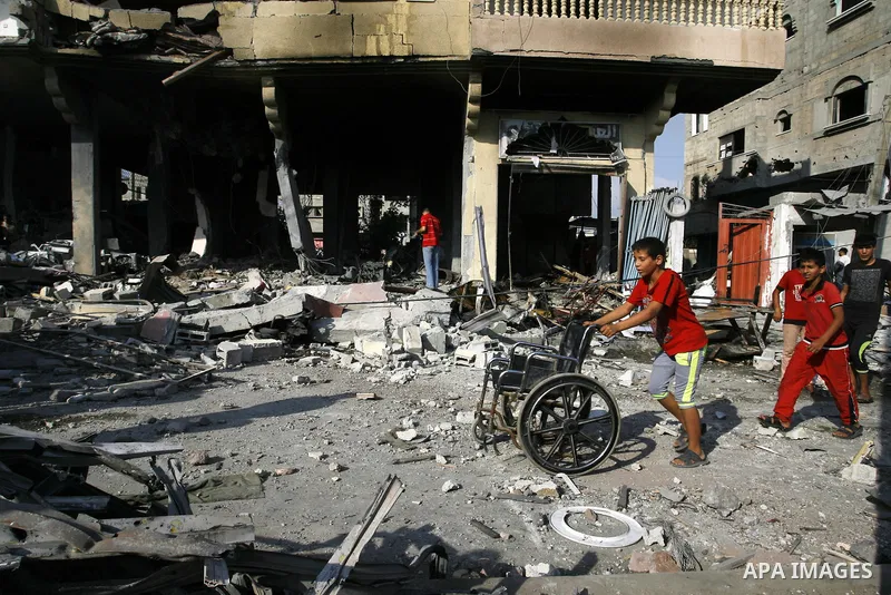 Palestinian children play near the remains of homes that were destroyed by an Israeli air strike on Rafah town in the southern Gaza Strip on August 26, 2014. Israeli fire killed 10 Palestinians across Gaza on August 25,...