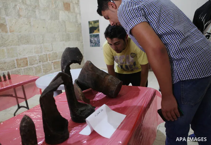 Palestinians attend the opening of gallery contains Israeli damaged equipment, in the West Bank city of Ramallah, on Aug. 26, 2014. Israeli air strikes launched before dawn on Tuesday killed two Palestinians and destroye...
