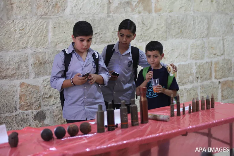 Palestinians attend the opening of gallery contains Israeli damaged equipment, in the West Bank city of Ramallah, on Aug. 26, 2014. Israeli air strikes launched before dawn on Tuesday killed two Palestinians and destroye...