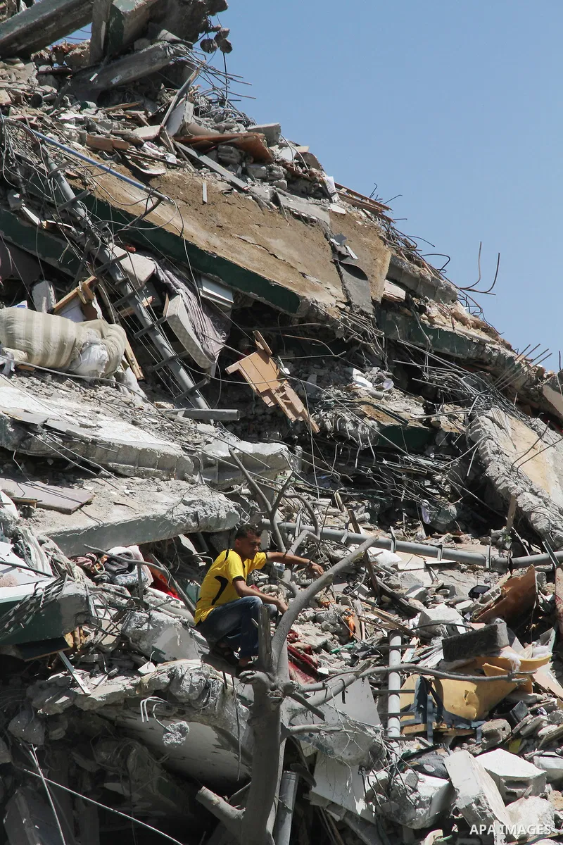 Palestinians look at the remains of one of Gaza's tallest apartment towers, which witnesses said was hit by an Israeli air strike that destroyed much of it, in Gaza City August 26, 2014. Israeli air strikes launched befo...