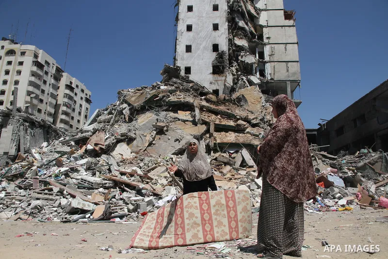 Palestinians look at the remains of one of Gaza's tallest apartment towers, which witnesses said was hit by an Israeli air strike that destroyed much of it, in Gaza City August 26, 2014. Israeli air strikes launched befo...