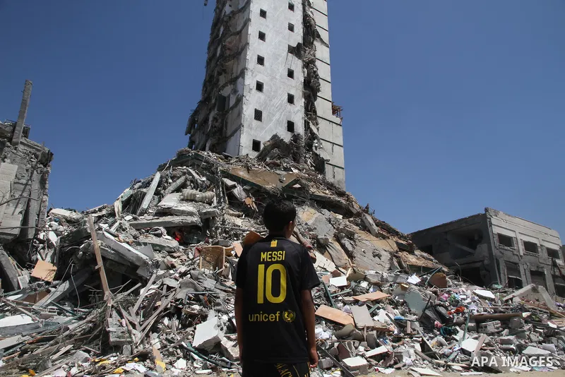 A Palestinian boy looks at the remains of one of Gaza's tallest apartment towers, which witnesses said was hit by an Israeli air strike that destroyed much of it, in Gaza City August 26, 2014. Israeli air strikes launche...