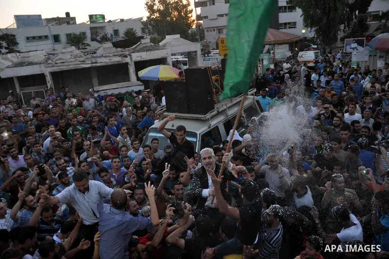 Hamas spokesman Fawzi Barhoum (C) is carried by Palestinians as they celebrate what they said was a victory over Israel following a ceasefire in Gaza City August 26, 2014. Israel has accepted an Egyptian proposal for a G...