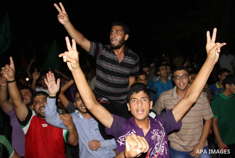 Palestinians gather in the streets celebrating a ceasefire in Khanyounis southern Gaza strip, on 26 August 2014. Palestinian President Mahmoud Abbas announced on 26 August 2014 an Egyptian-brokered ceasefire proposal to...