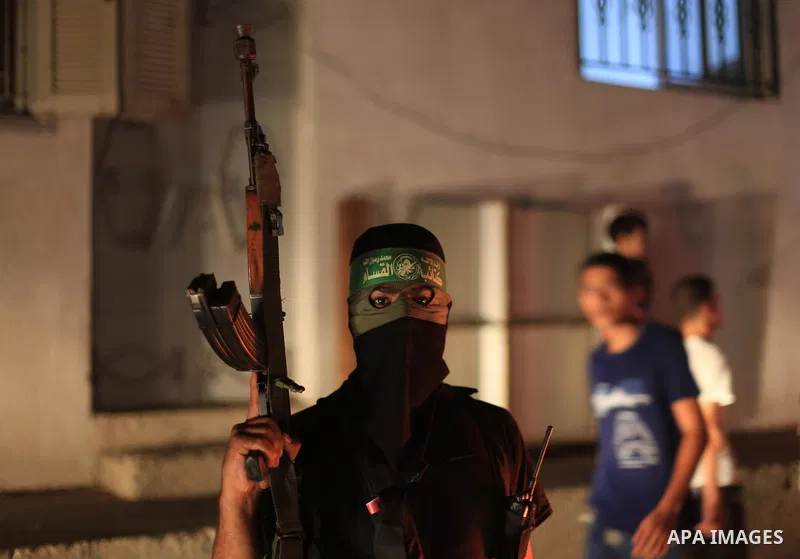A Palestinian Hamas militant holds his weapon as he celebrate with people what they said was a victory over Israel, following a ceasefire in Gaza City August 26, 2014. A ceasefire agreement between Israel and the Palesti...